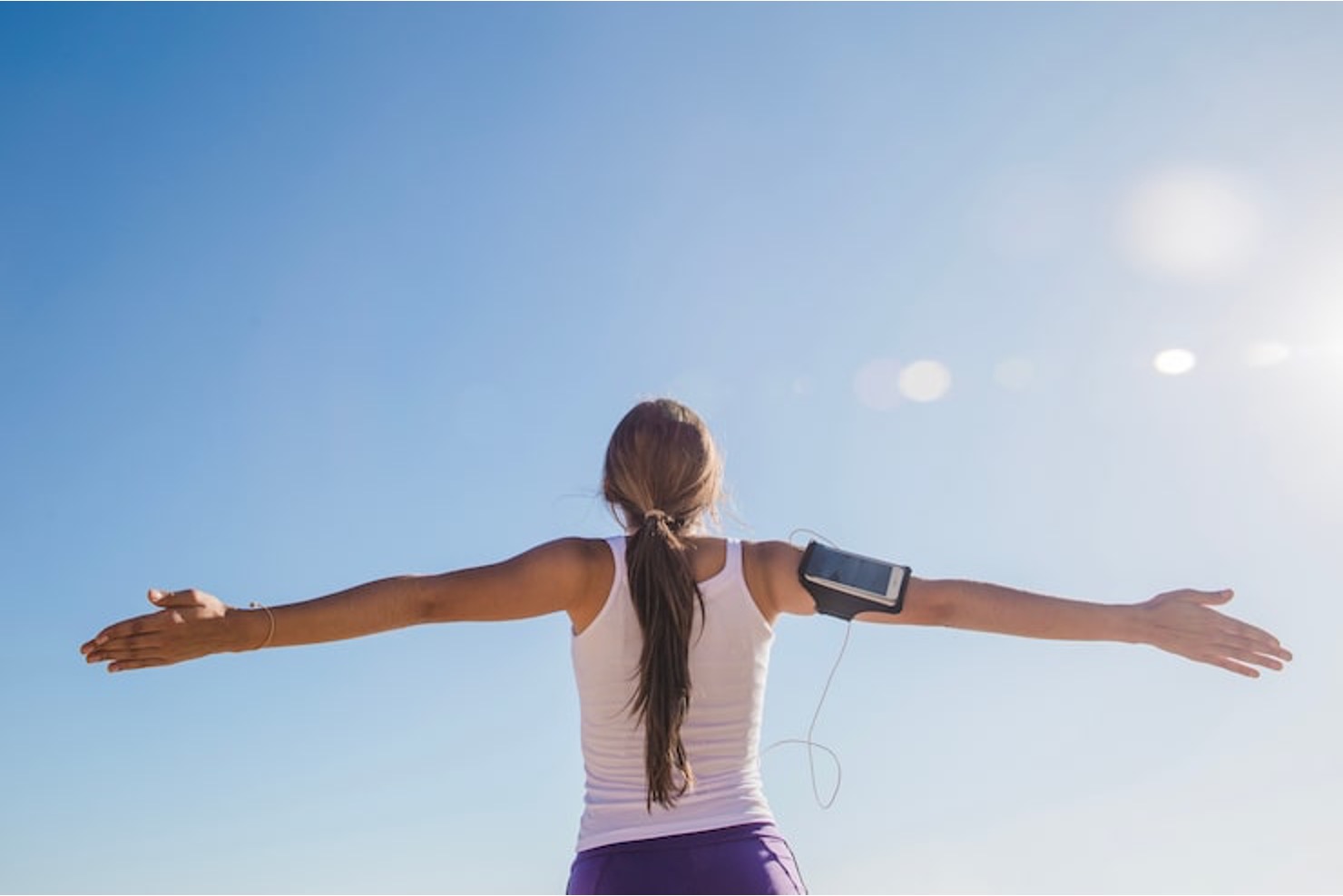 Woman with arms outstretched facing the sky